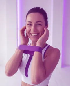 Donna sorridente con la fascia elastica lilla